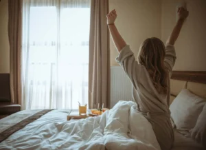 Donna su un letto con un vassoio con la prima colazione