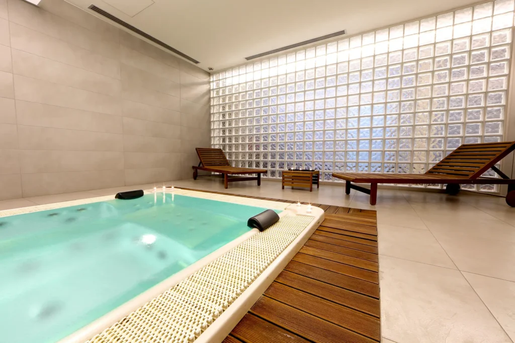 Dettaglio della Spa dell'hotel, con primo piano della piscina idromassaggio e dei lettini dove rilassarsi