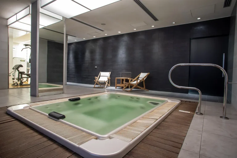 La spa dell'hotel, con piscina idromassaggio in primo piano e, sullo sfondo, uno scorcio della palestra